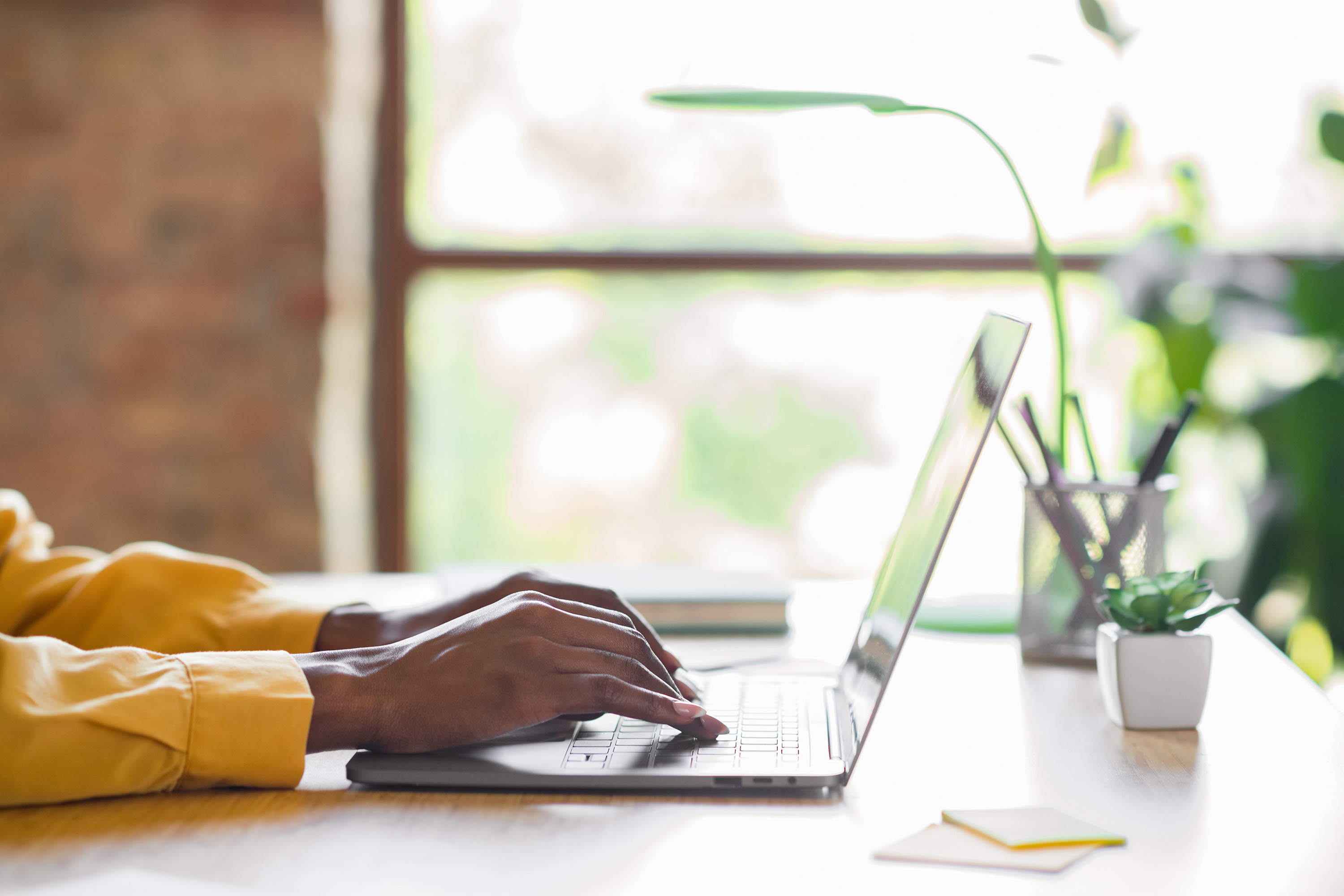 Profile photo of girl hands typing on laptop table wear yellow shirt at home